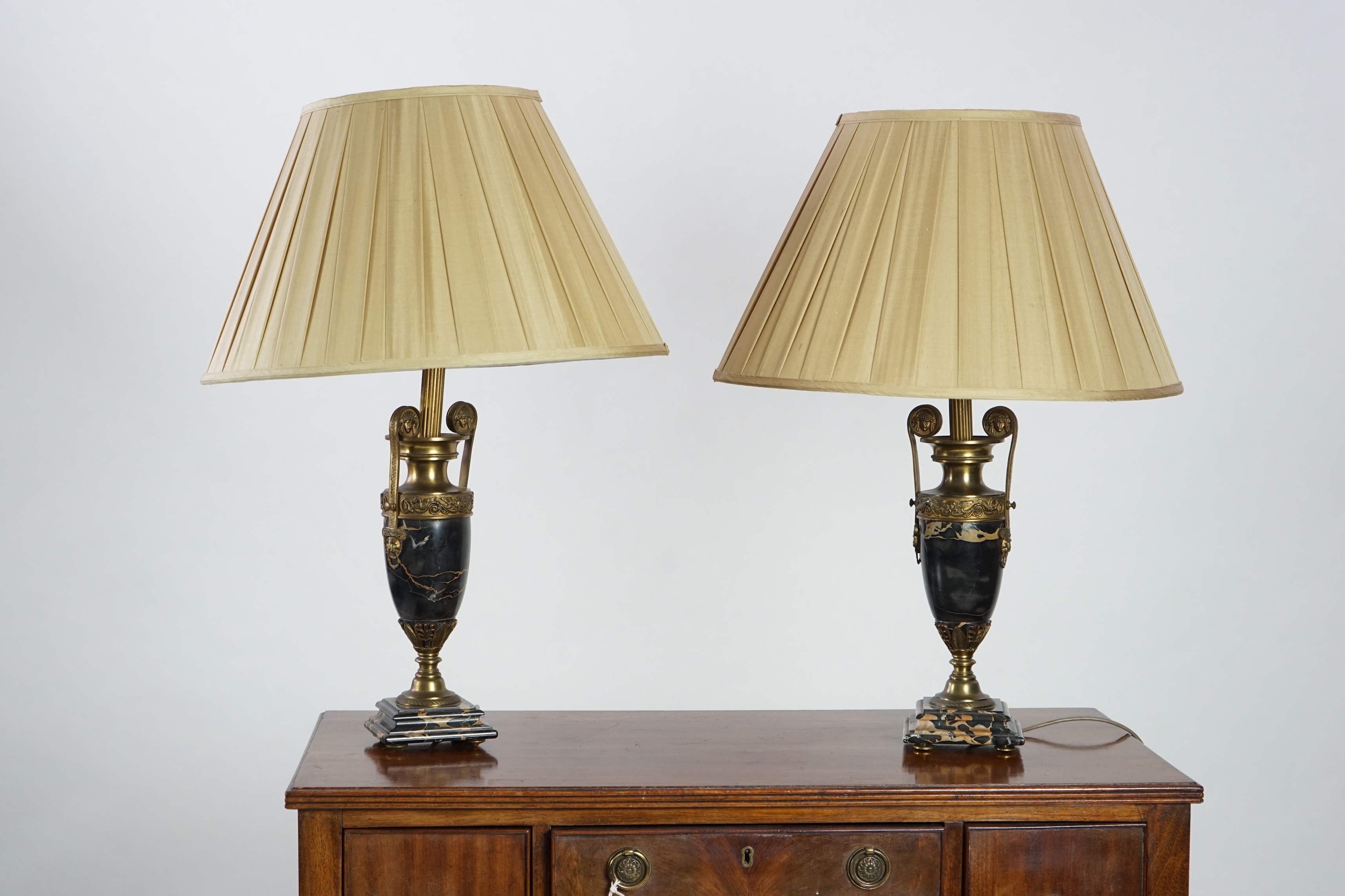 A pair of French Empire style ormolu mounted black marble table lamps